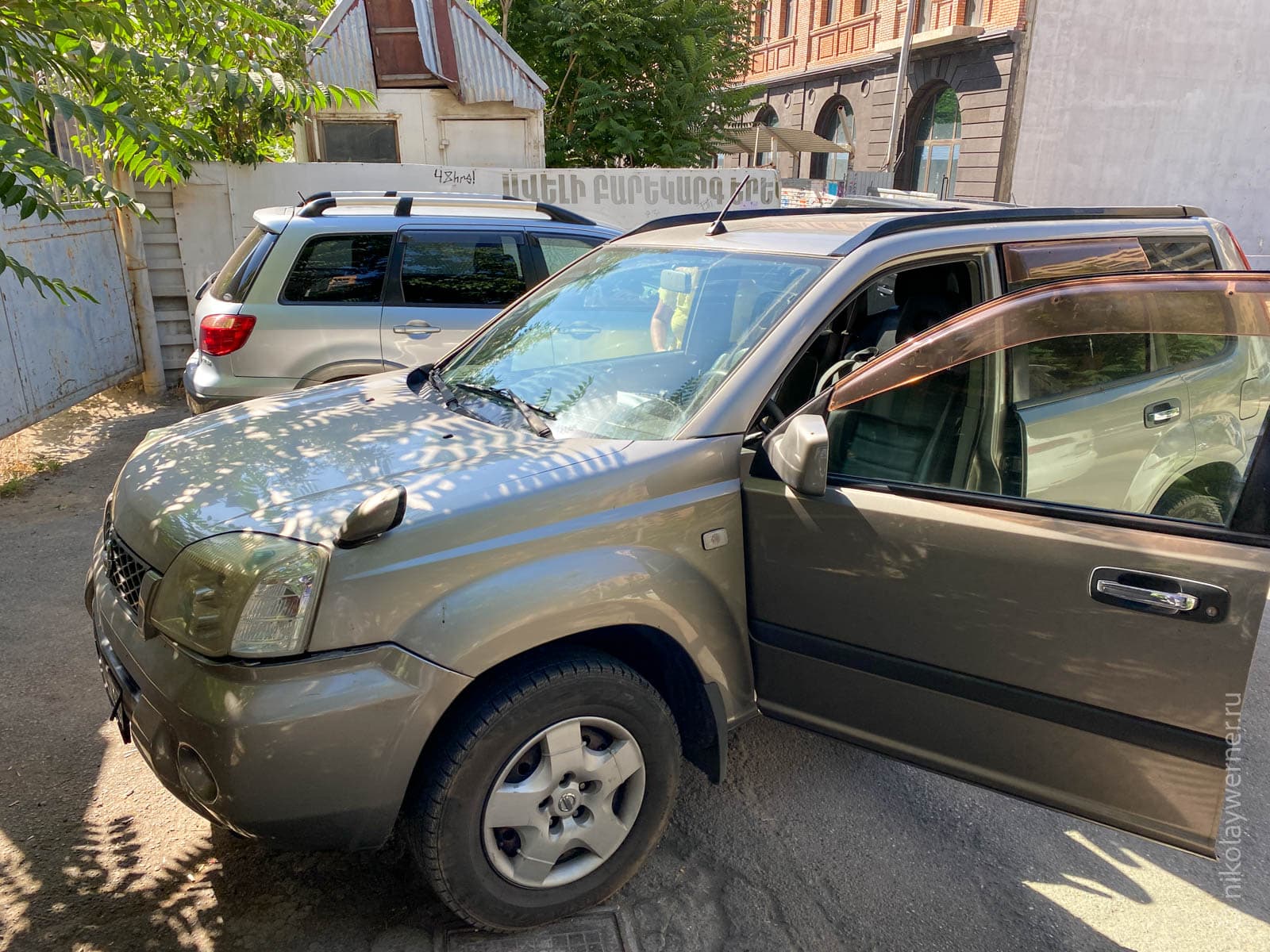 Серебристый Ниссан Икс-трейл на парковке