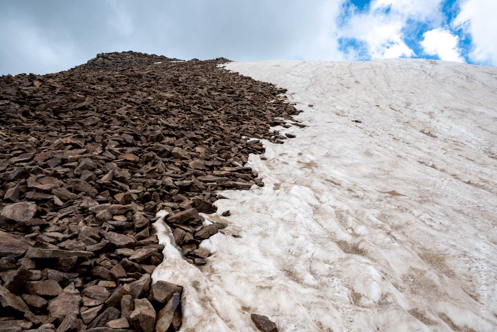 Снежник на каменистой осыпи у берегов озера Кари