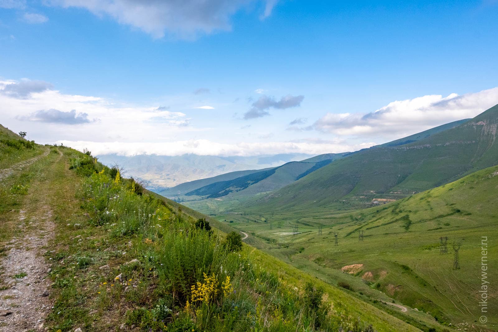 Узкая грунтовая горная дорога идущая по краю крутого обрыва